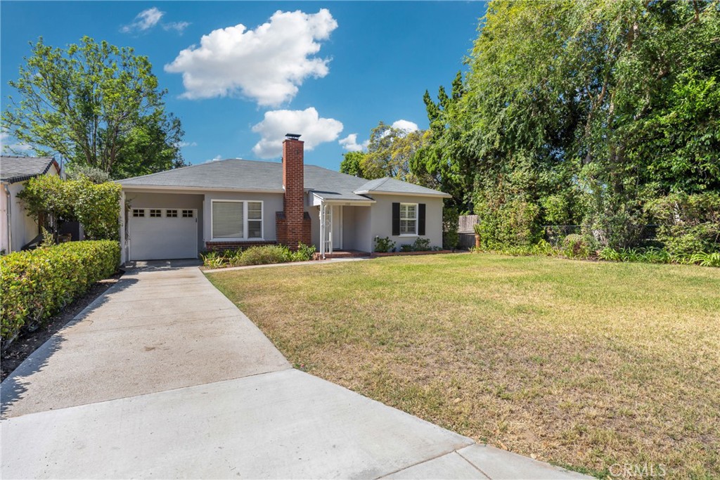 a front view of a house with a yard and trees