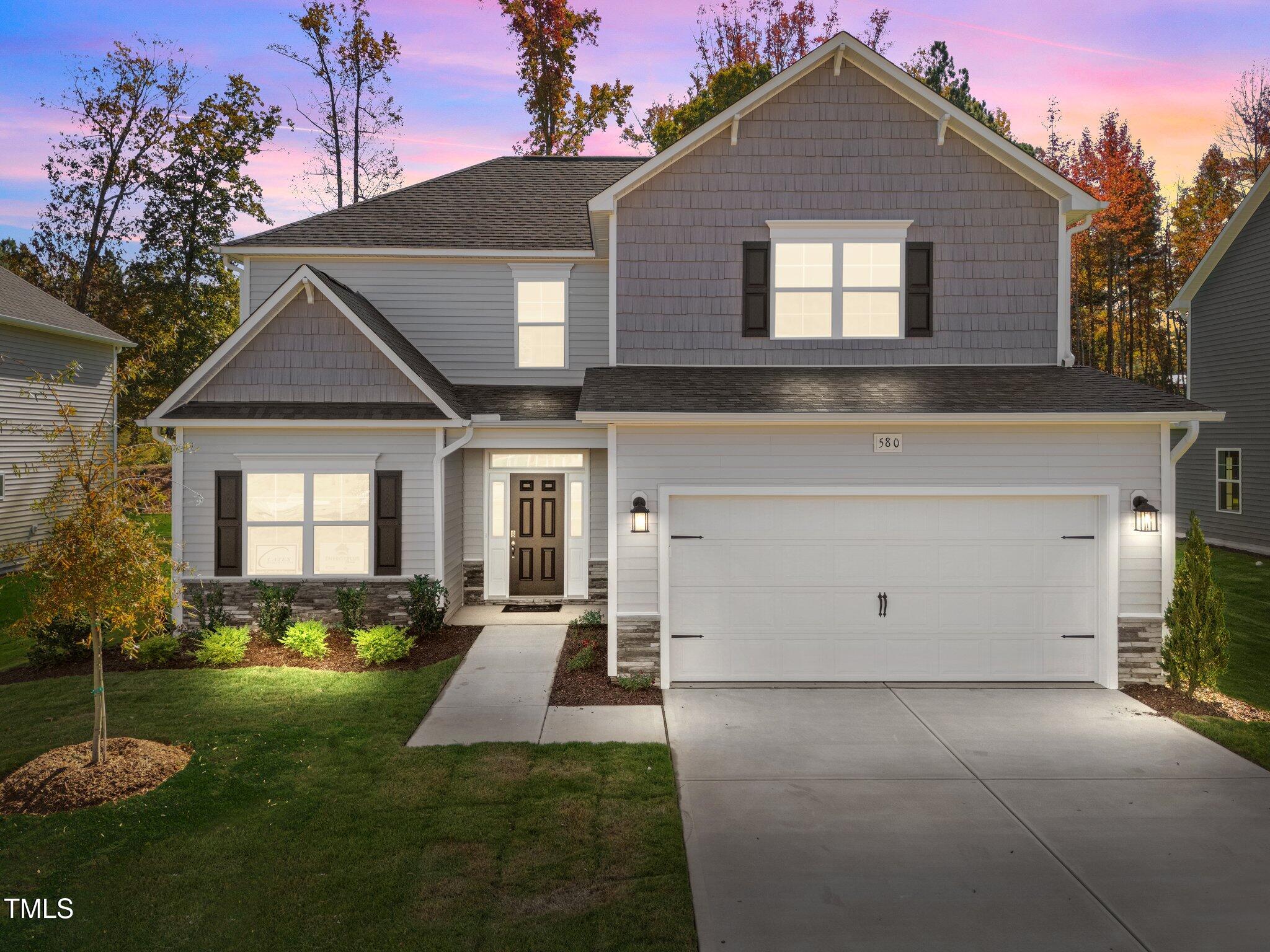 a front view of a house with a yard and garage