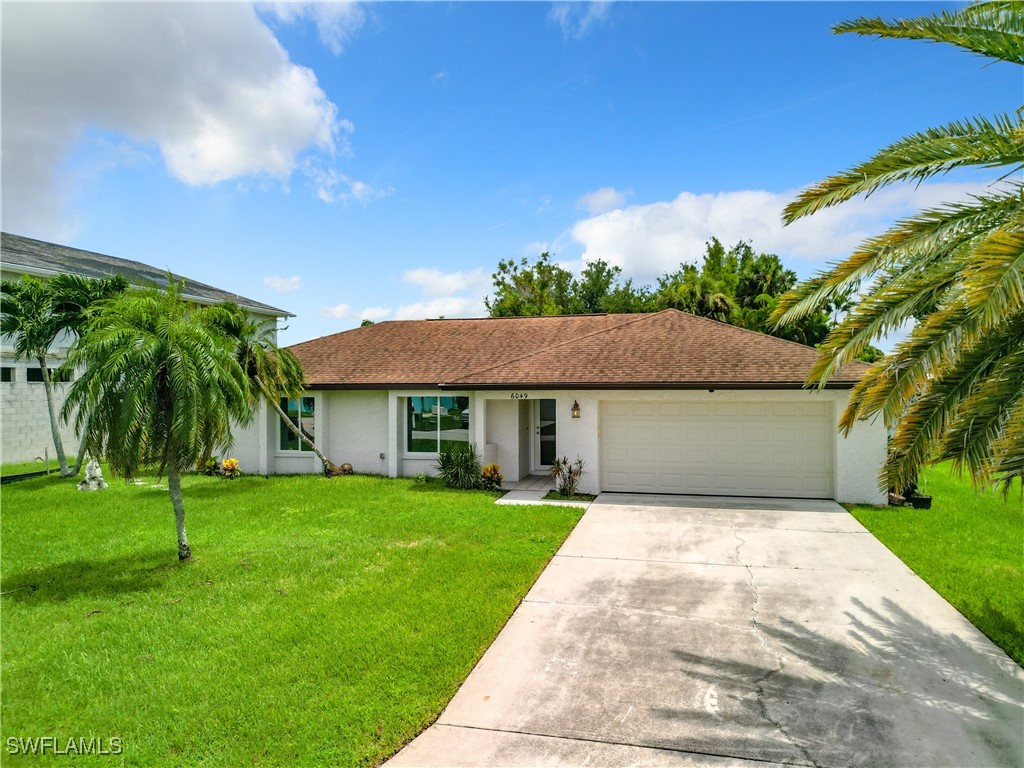 a front view of a house with a yard and trees