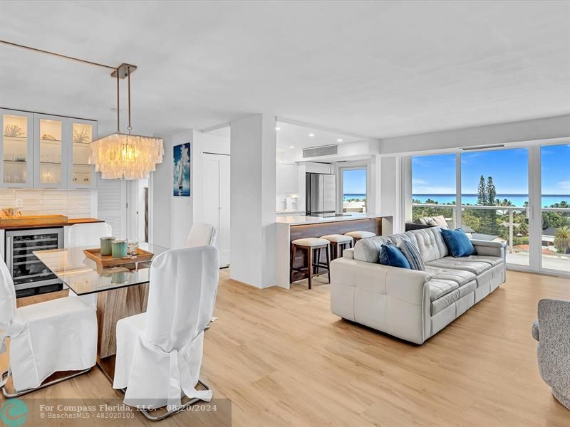 a living room with furniture kitchen view and a chandelier