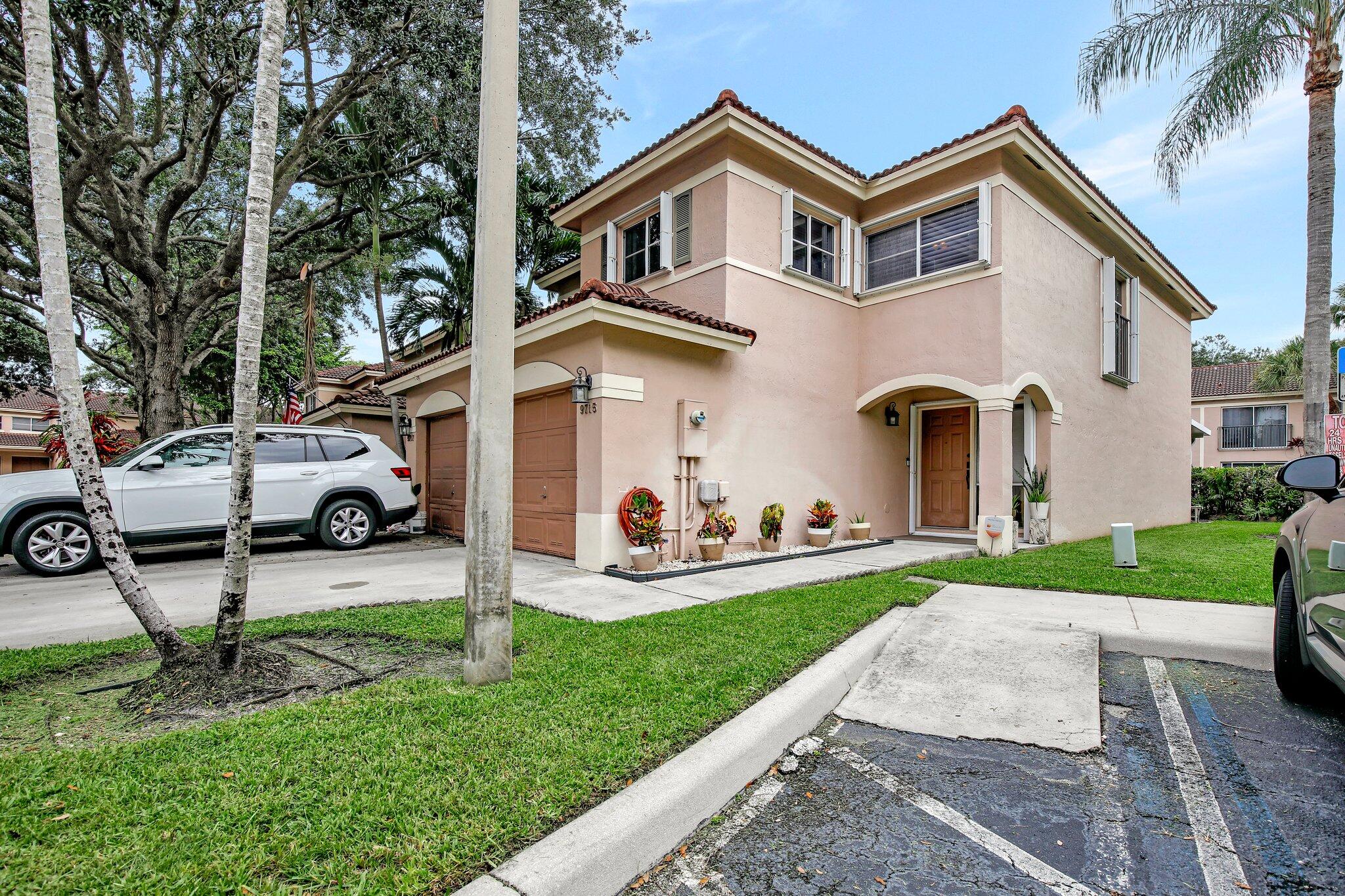 a front view of a house with garden and parking