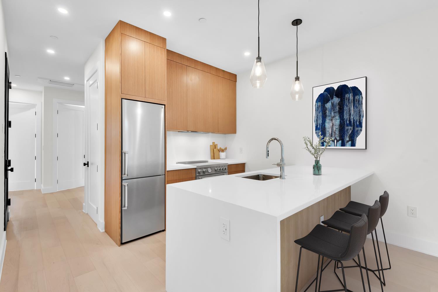 a kitchen with stainless steel appliances a refrigerator sink and white cabinets