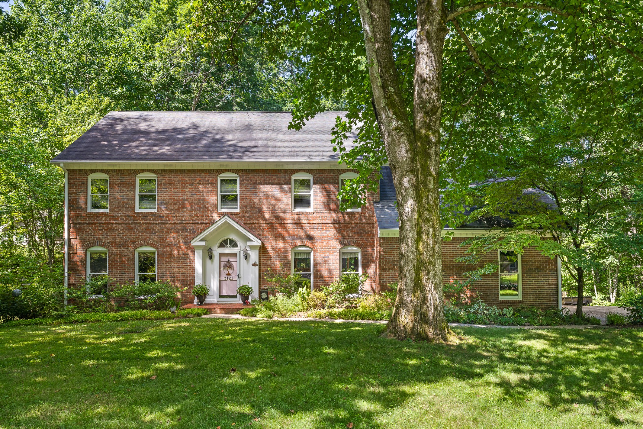 a front view of a house with a garden