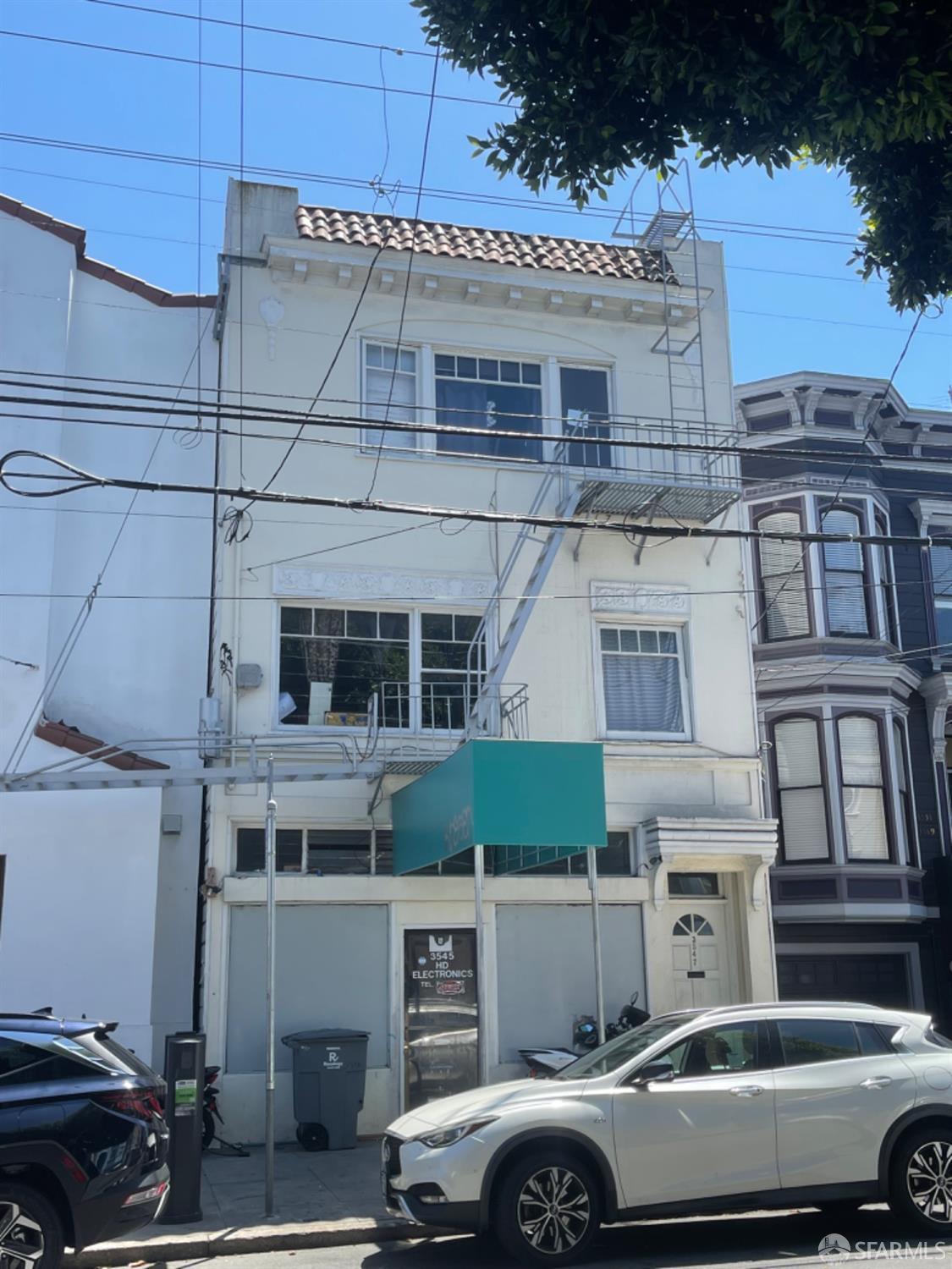 a front view of a building with cars parked