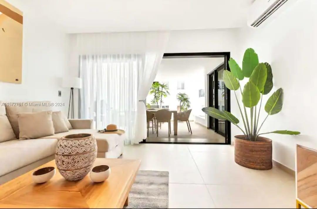 a living room with furniture flowerpot and wooden floor