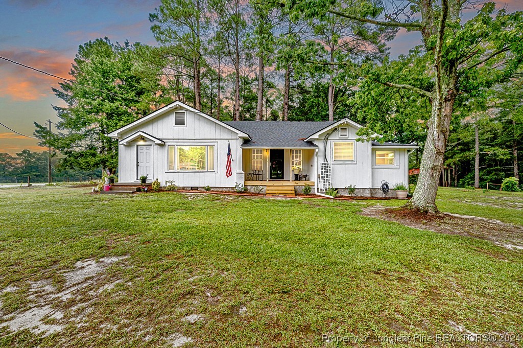 a front view of a house with a yard and trees