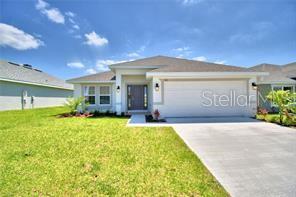 a front view of a house with a yard and garage