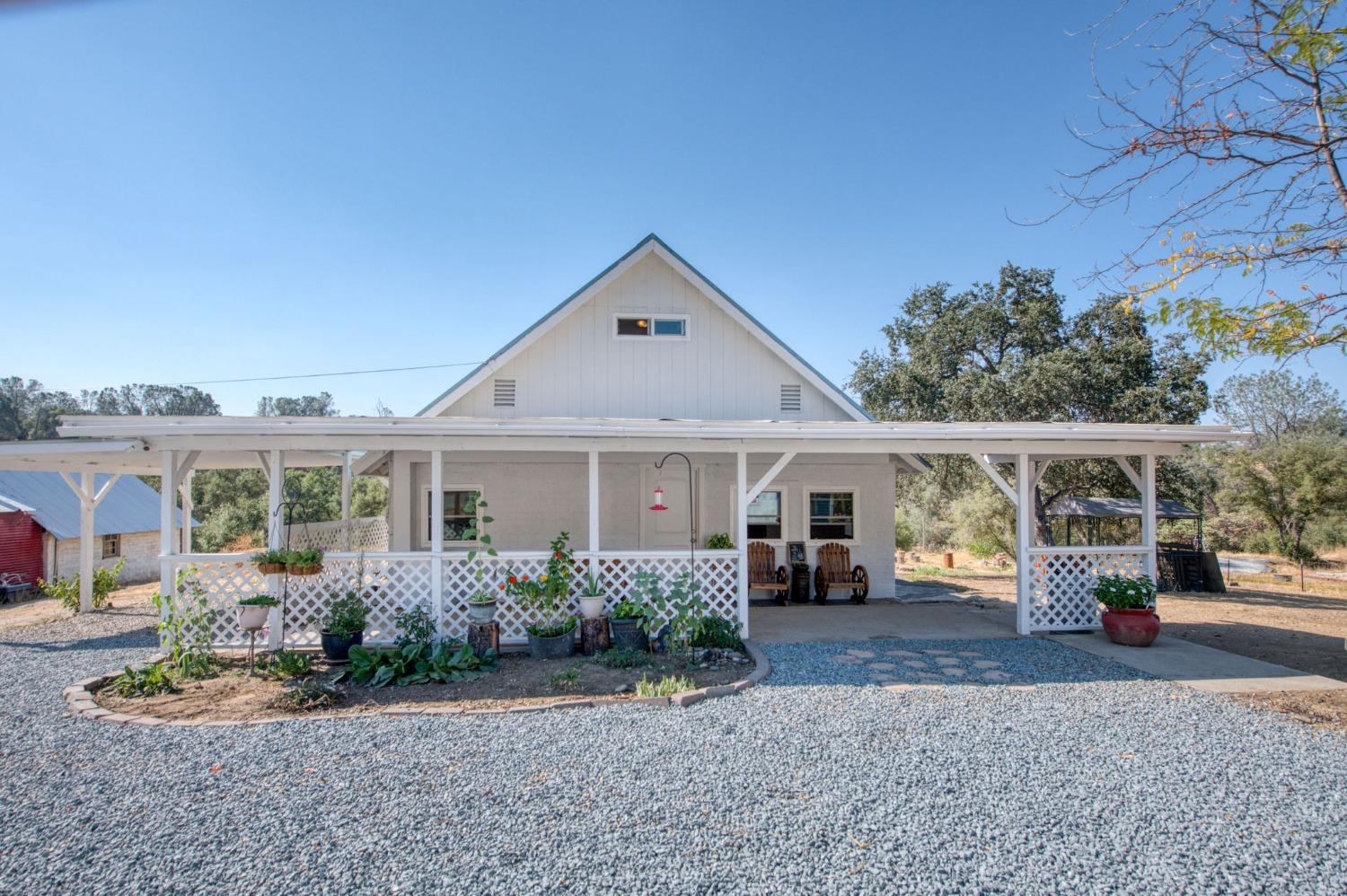 a front view of a house with a yard and potted plants