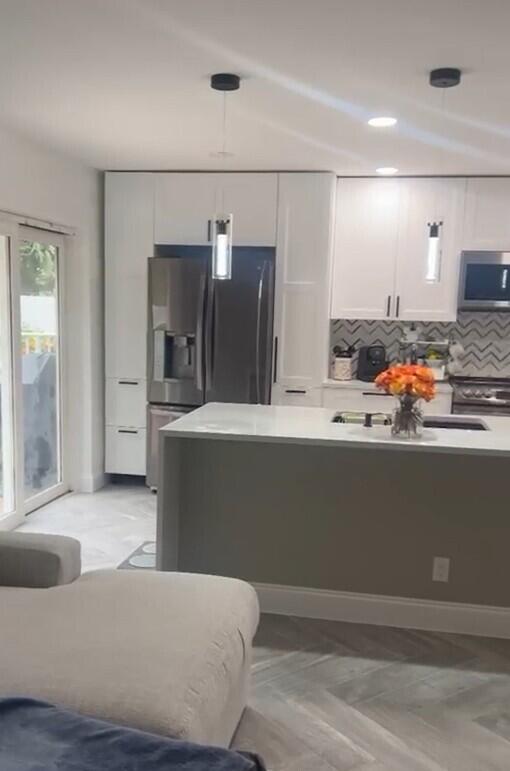 a living room with stainless steel appliances kitchen island granite countertop furniture and a kitchen view