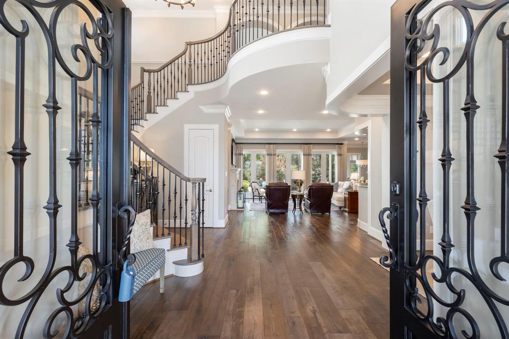 Step into the home through the impressive wrought-iron front doors that open to the foyer.