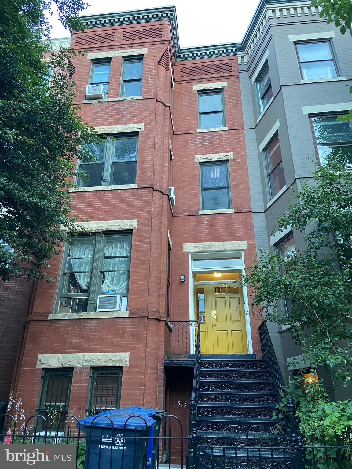 a view of a brick house with many windows and a yard