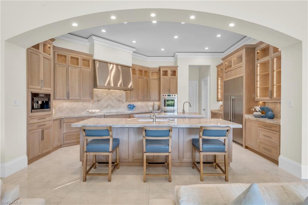 a kitchen with a sink table and chairs