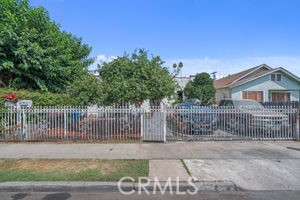 a view of a house with a small yard and wooden fence