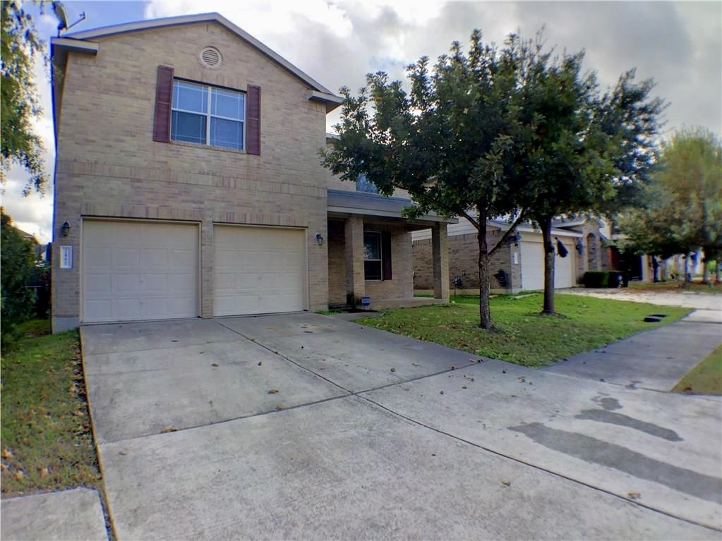 a front view of a house with a yard and garage