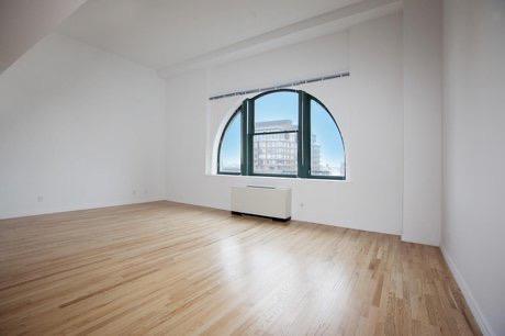 an empty room with wooden floor and a window