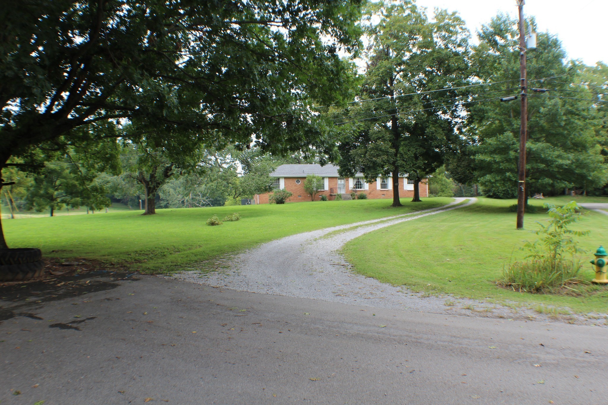 Small driveway entrance into the 2972 Melvin Rd property. Beautiful fields, trees, barn, & more.