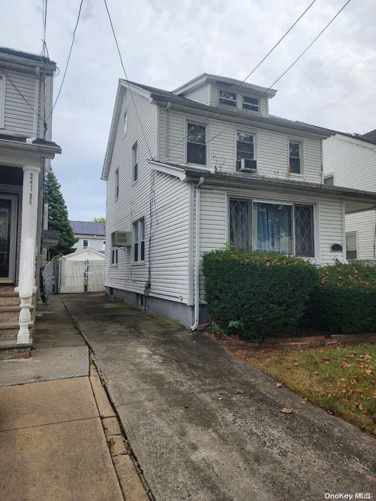 a view of a grey house with a yard