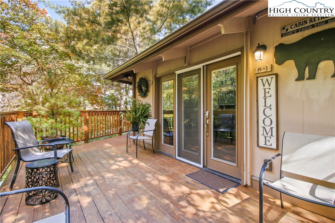 a view of a patio with table and chairs and floor to ceiling window