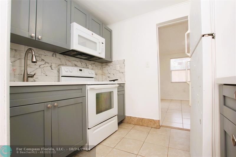 a kitchen with granite countertop a sink a stove and cabinets