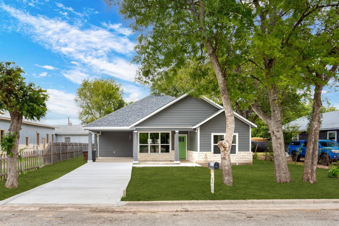 a front view of a house with a garden and trees