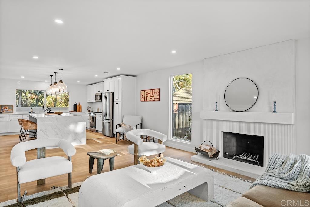 a living room with furniture a fireplace a rug and a window