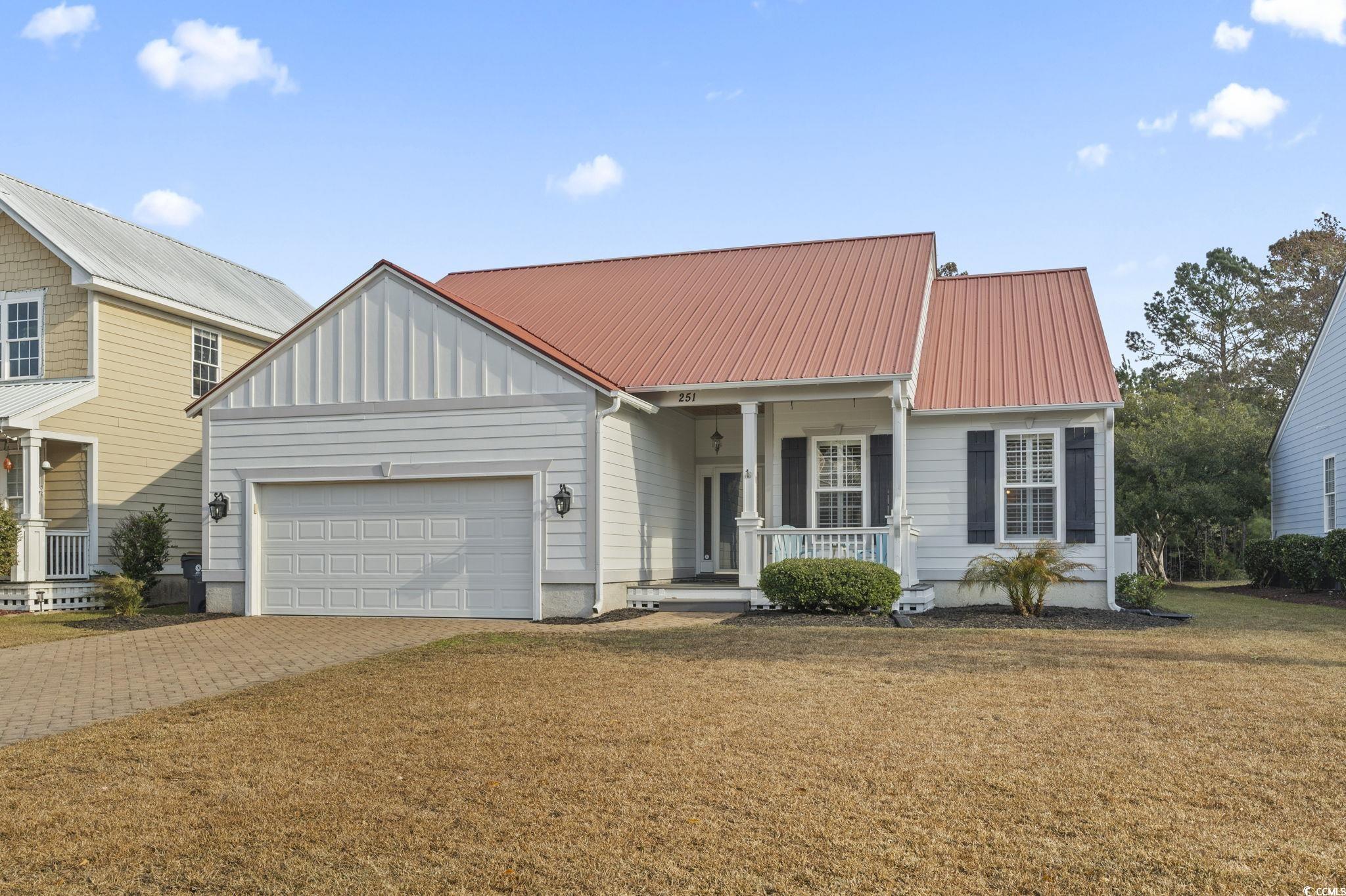 View of front of property featuring a porch, a gar