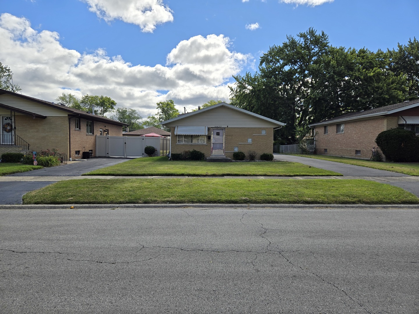 a view of a house with a big yard and large trees