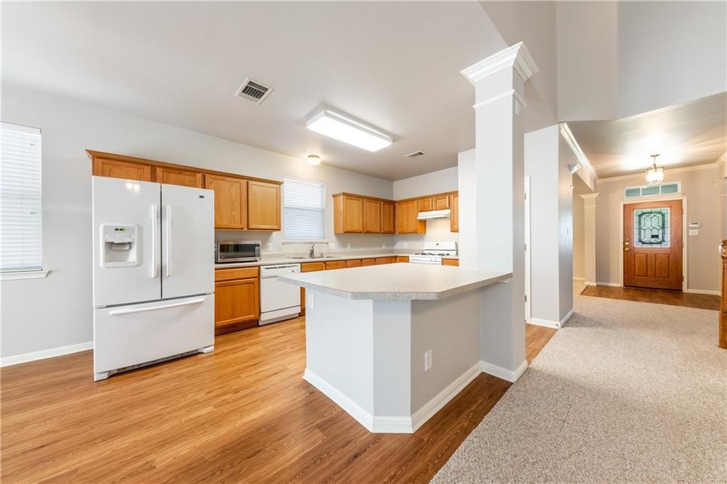 a large kitchen with stainless steel appliances a refrigerator and a stove top oven