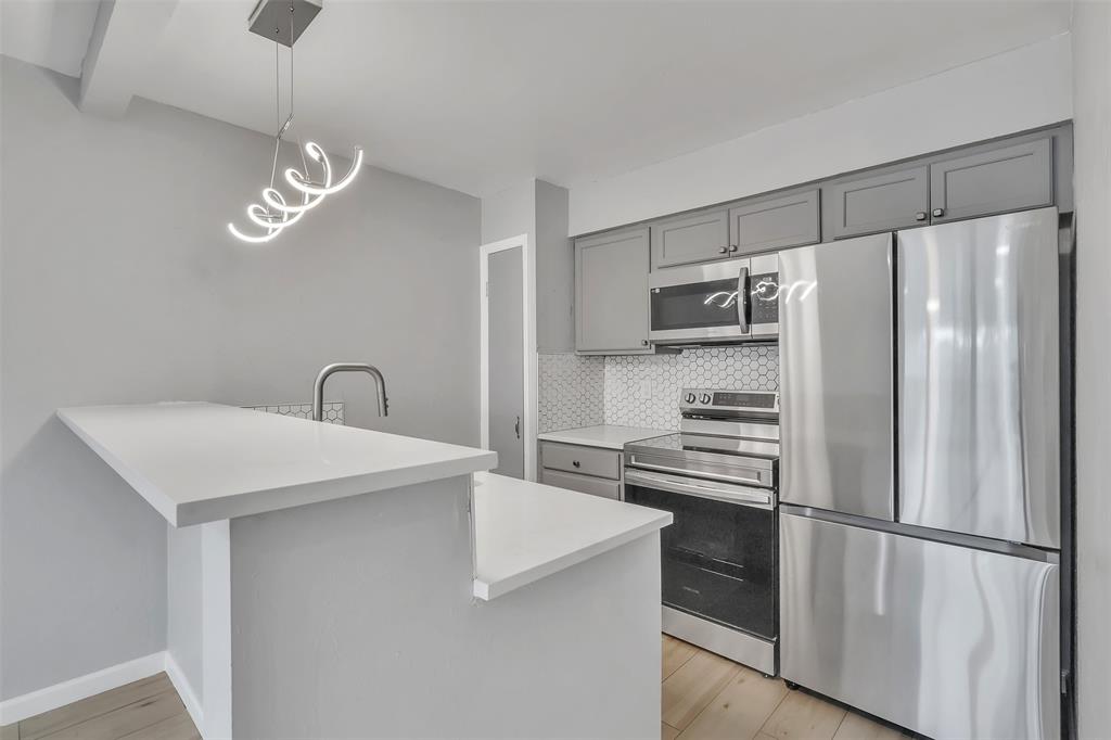 a kitchen with stainless steel appliances a refrigerator sink and cabinets