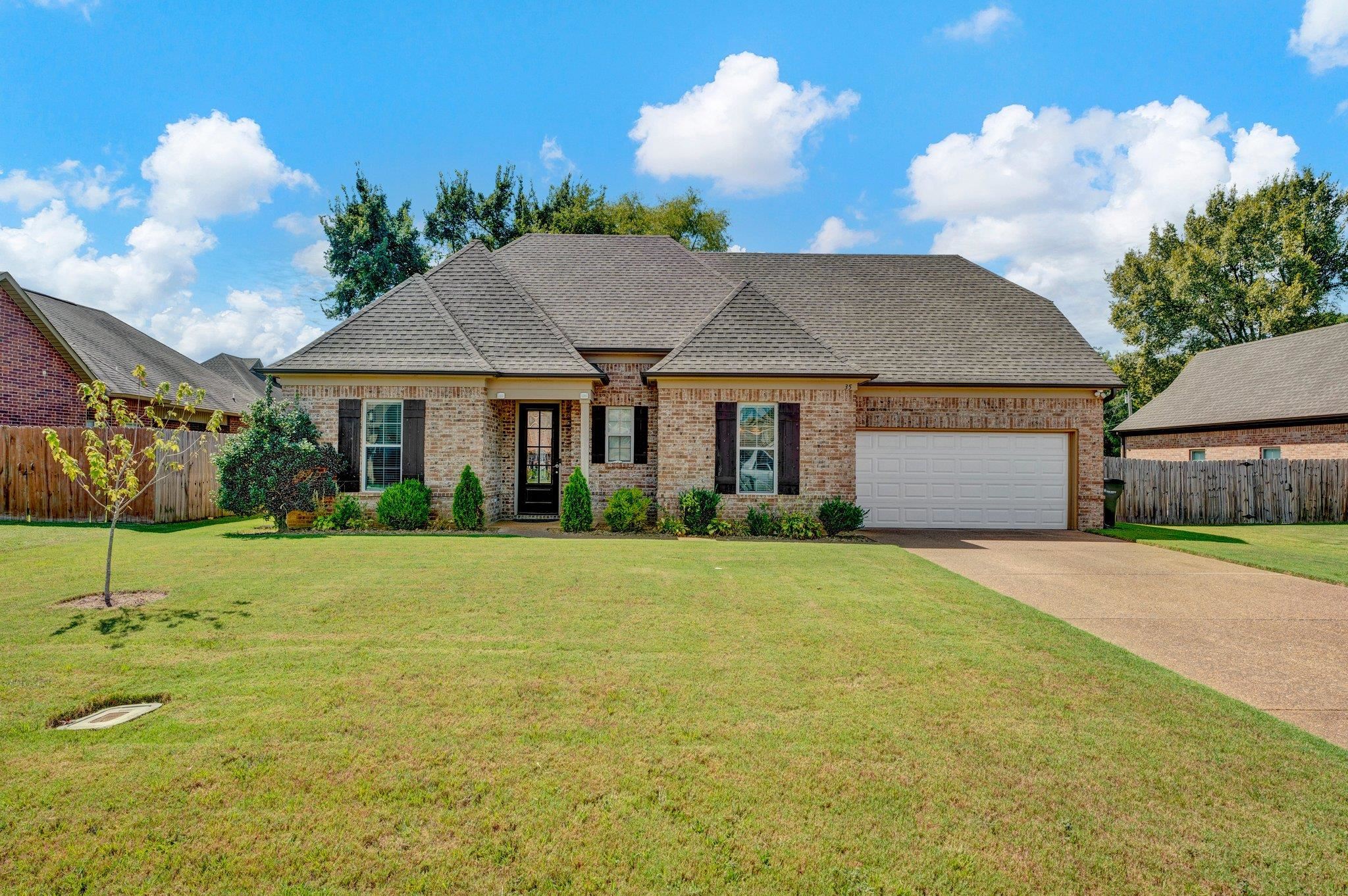 French country style house with a garage and a front lawn