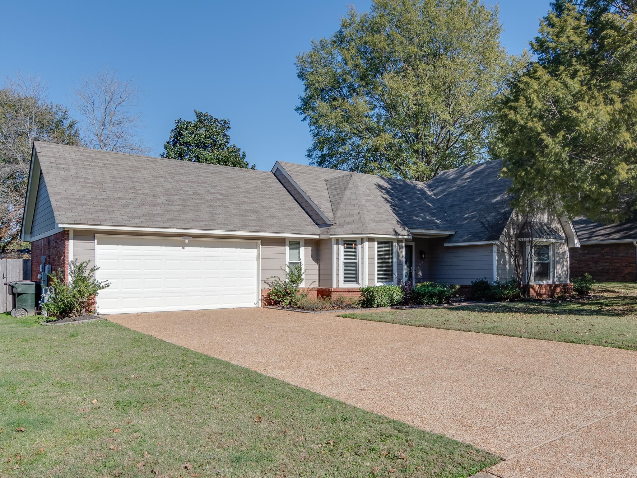 View of front of home with a garage and a front lawn