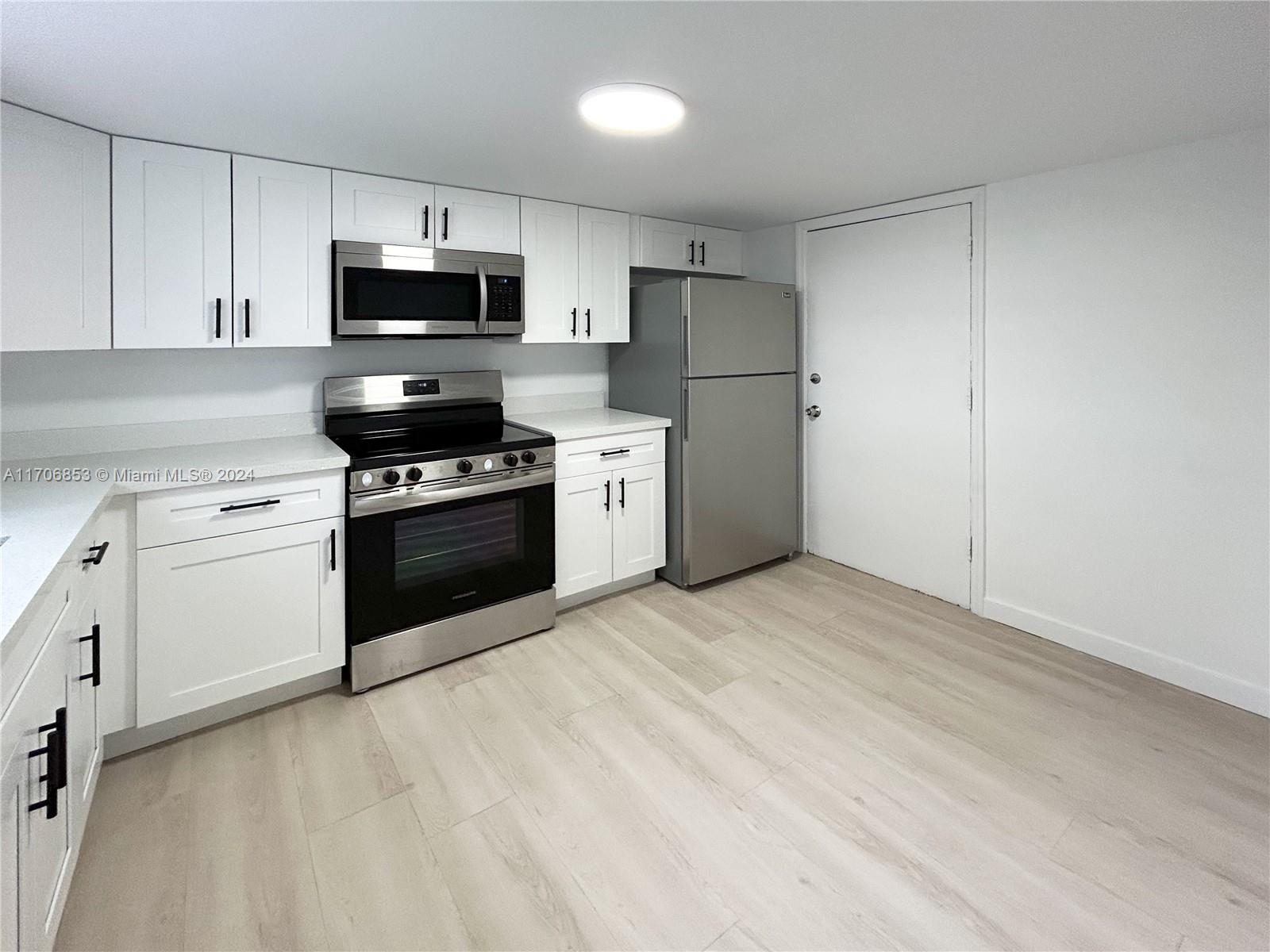 a kitchen with white cabinets and stainless steel appliances