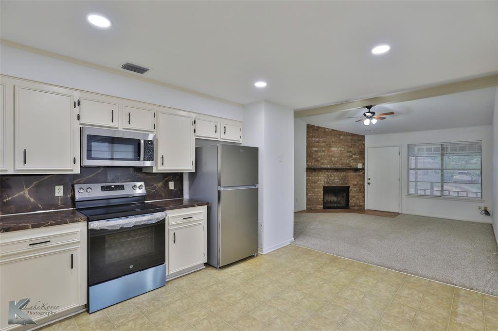 a kitchen with granite countertop a refrigerator stove and oven