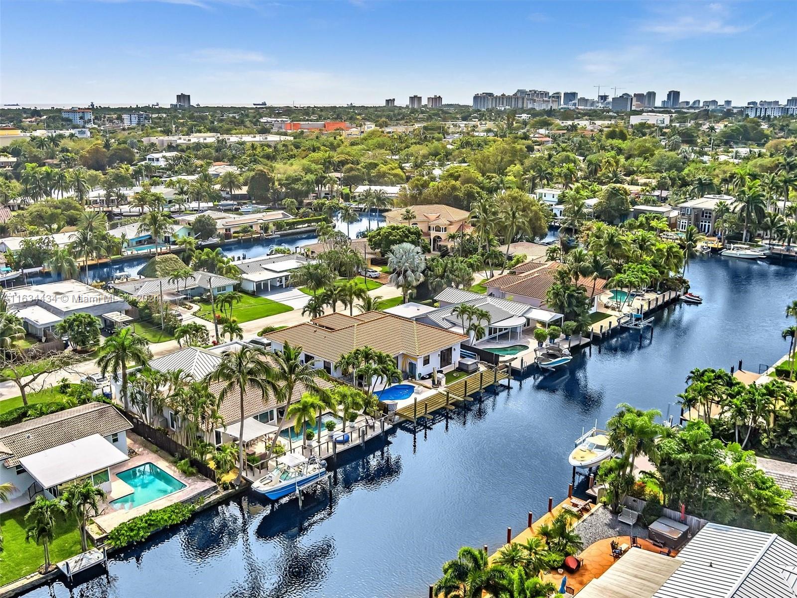 an aerial view of a city with lots of residential buildings ocean and mountain view in back