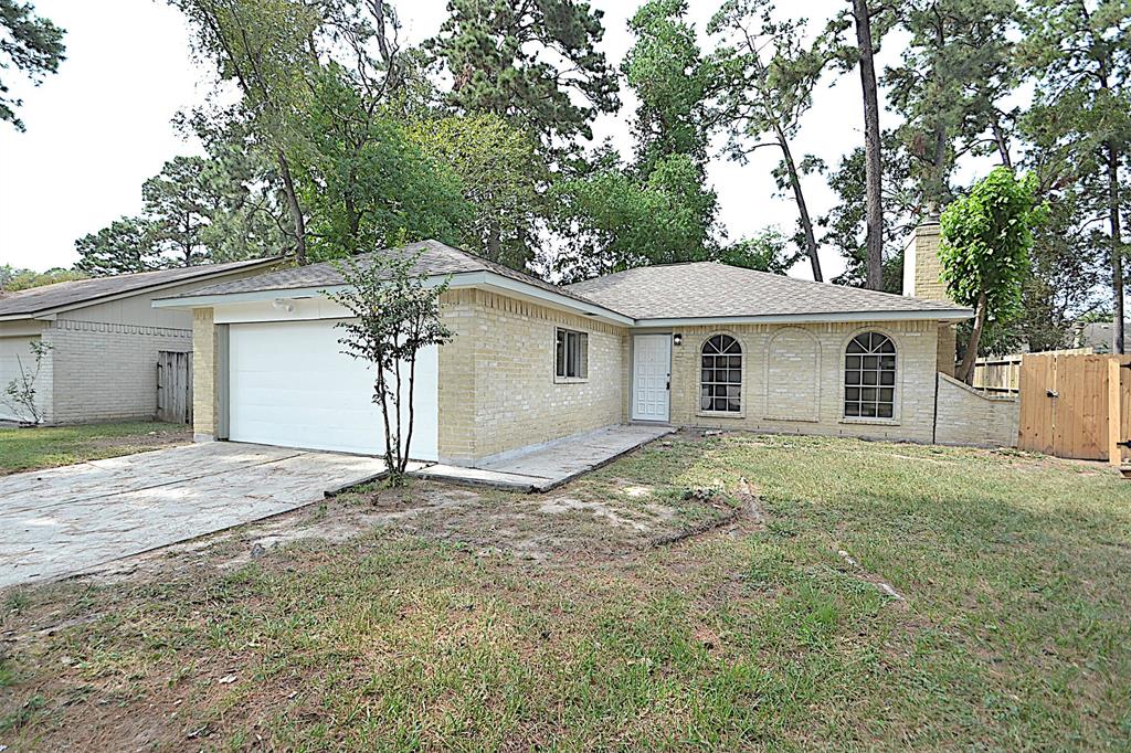 a view of a house with a yard and large tree