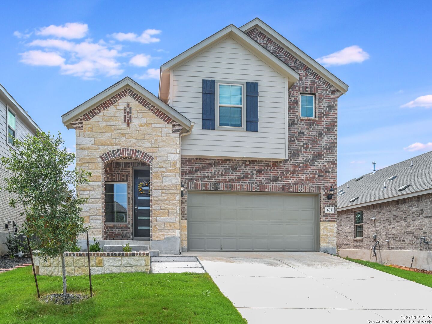 a front view of a house with a yard and garage