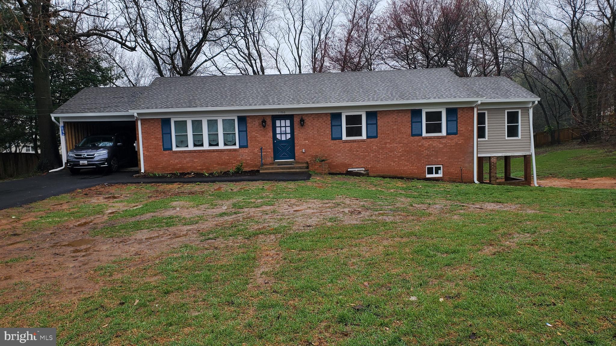 a view of a yard in front of a brick house with large windows