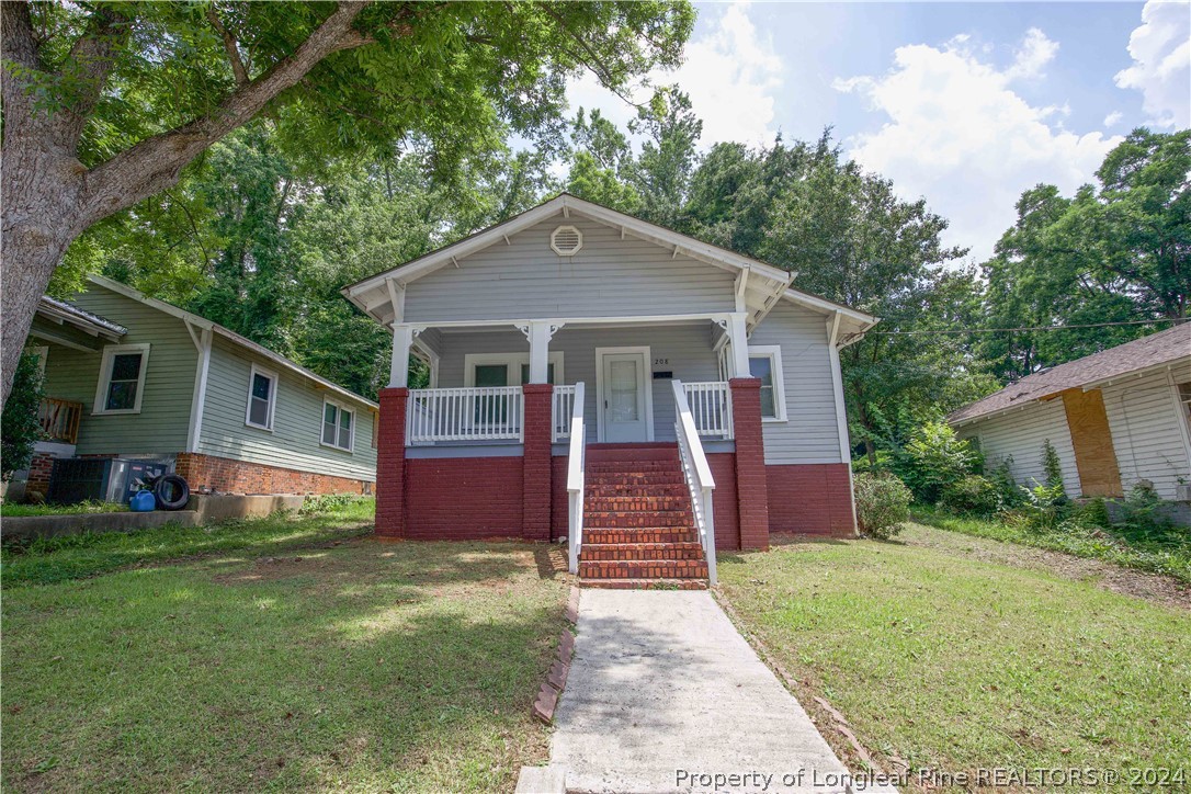 a front view of house with yard and trees in the background