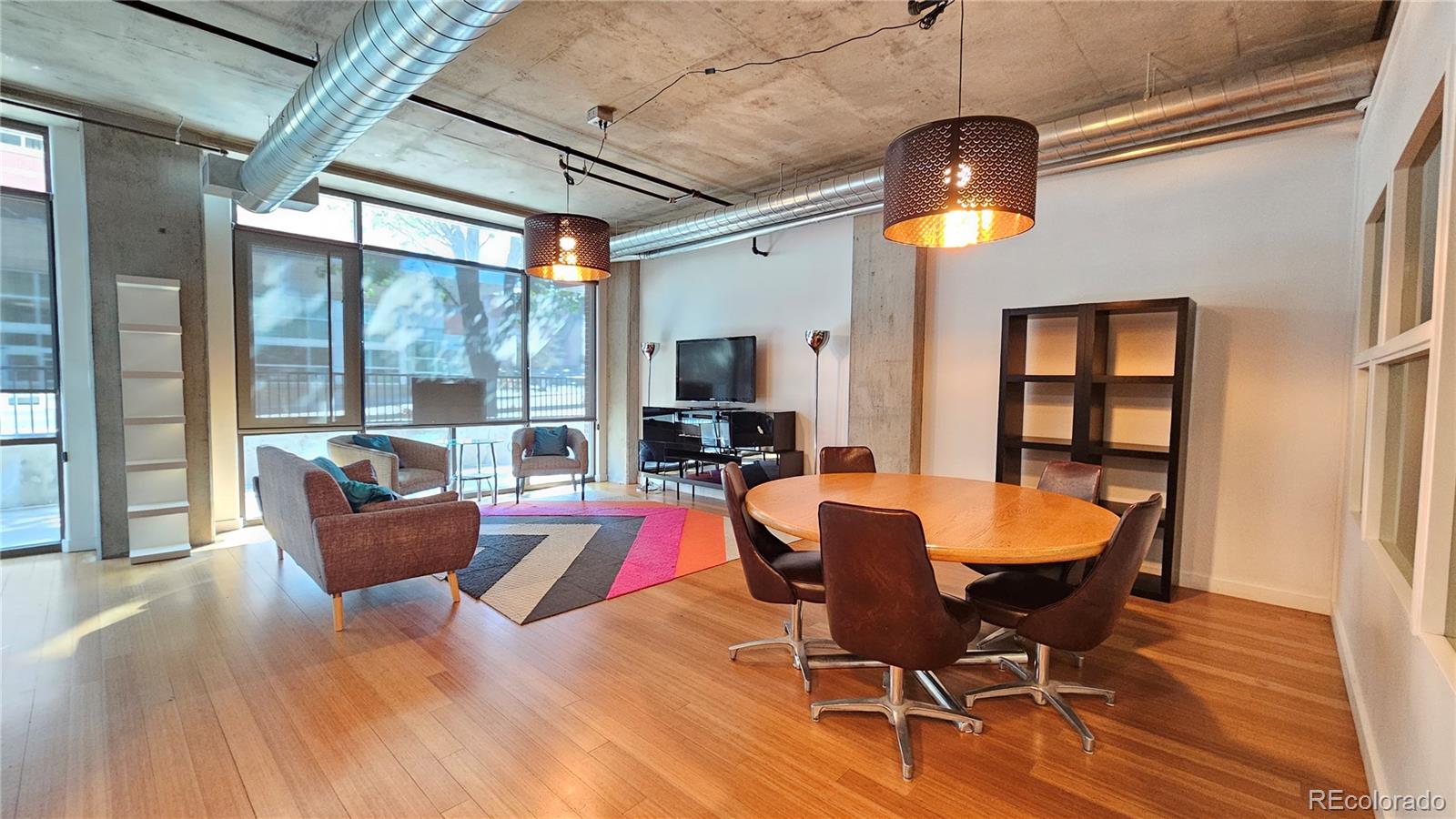 a dining room with furniture a chandelier and wooden floor