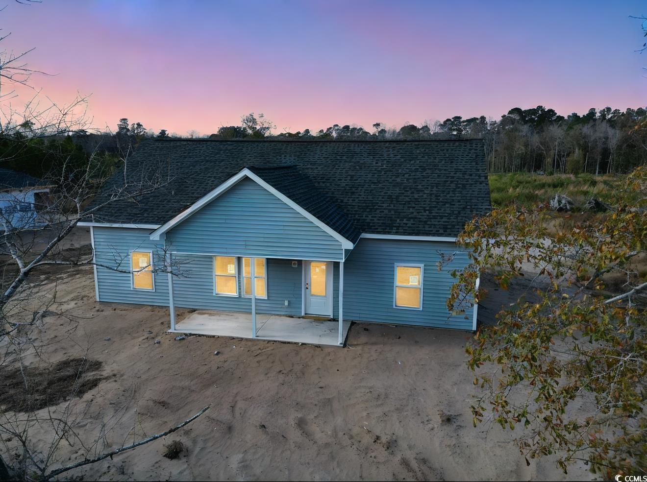 Back house at dusk featuring a patio area