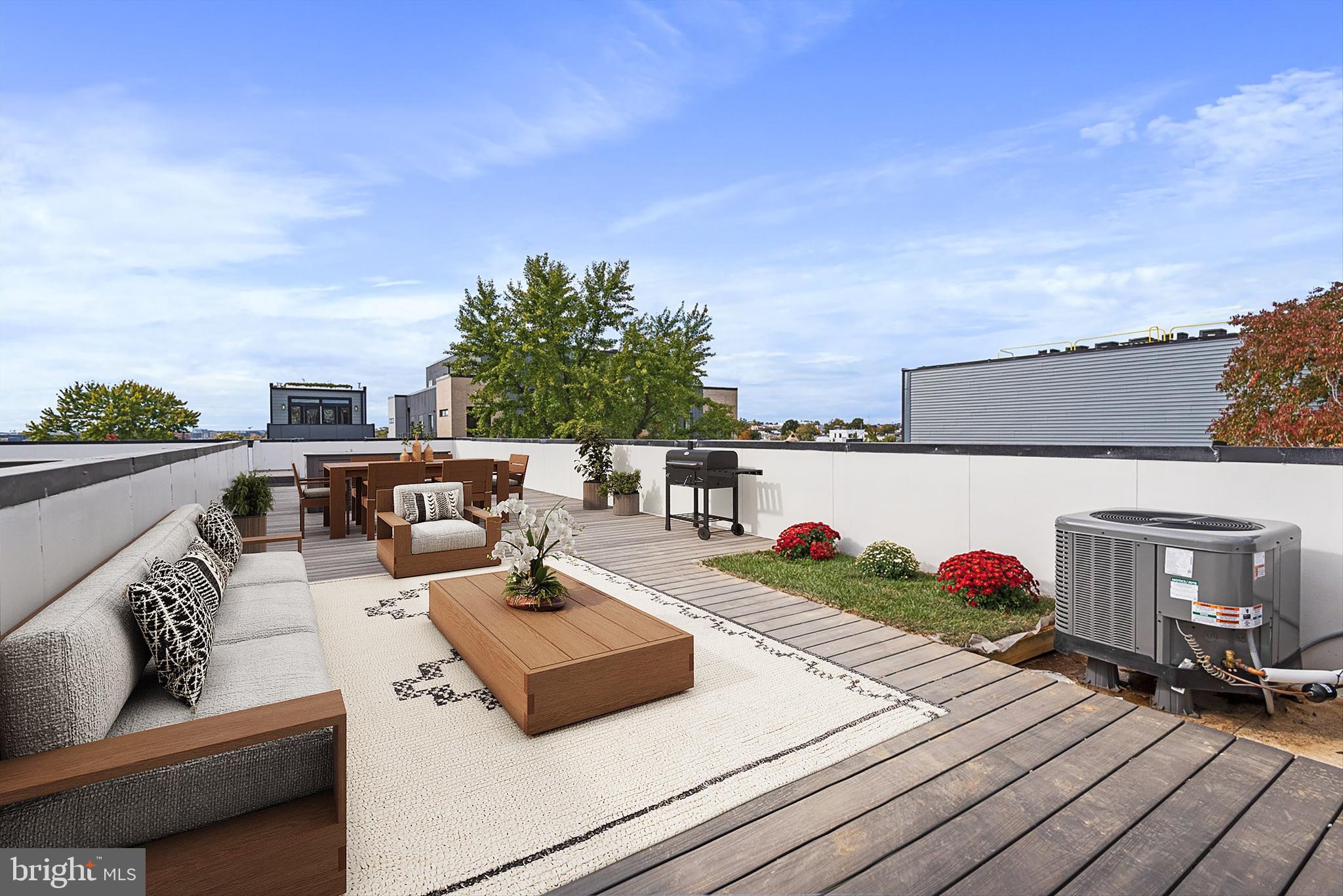 a view of roof deck with couches and potted plants