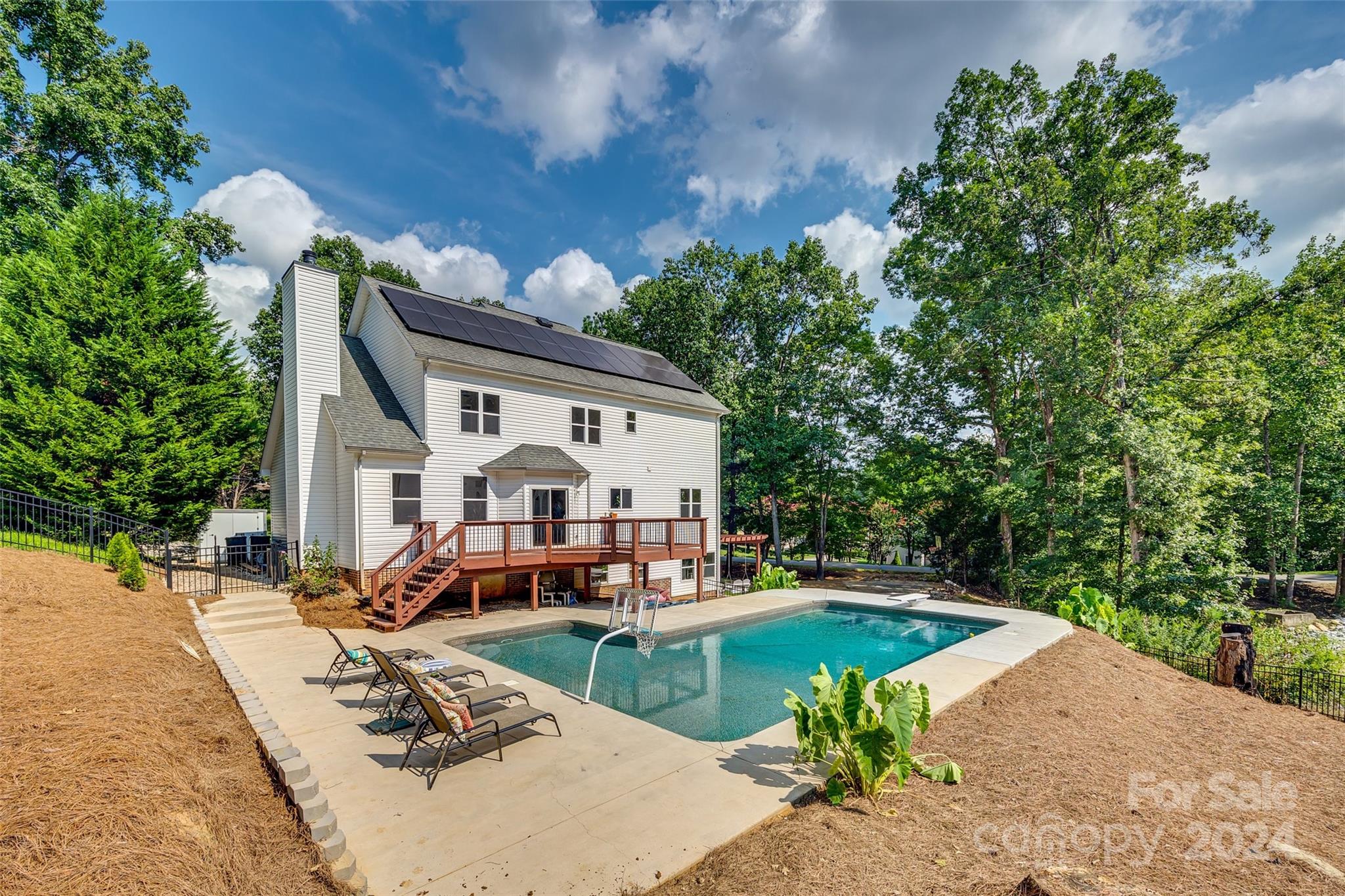 a swimming pool view with a seating space and garden view