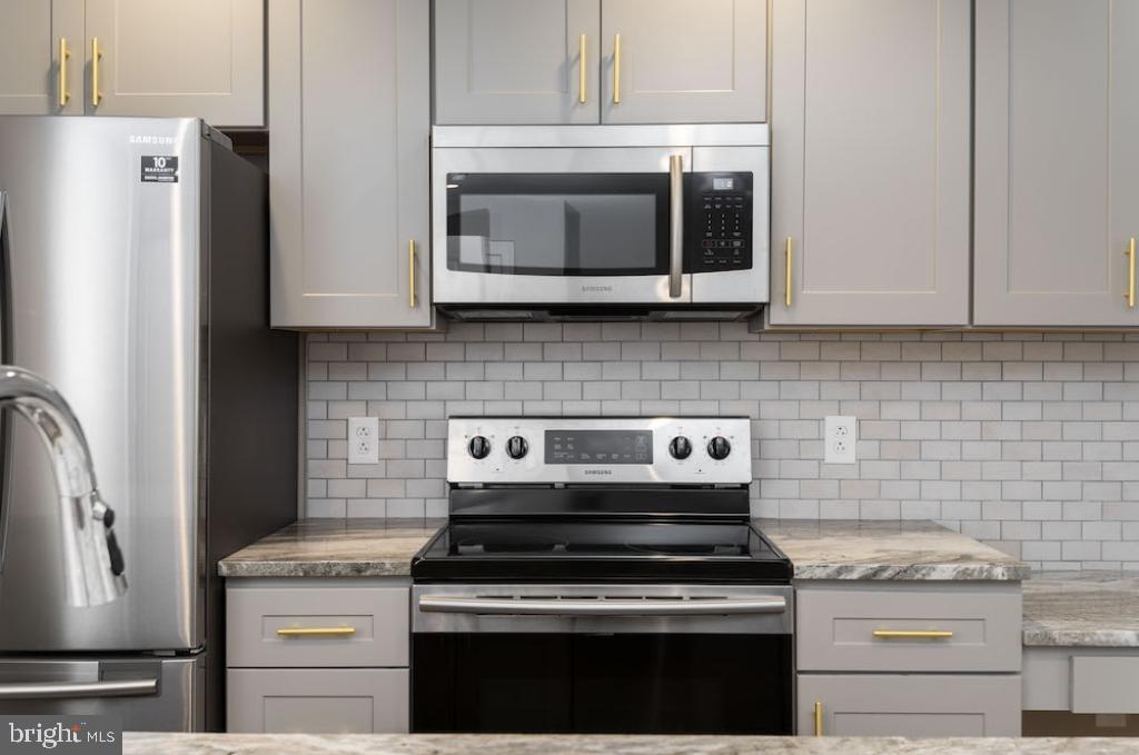 a kitchen with stainless steel appliances granite countertop white cabinets and a stove