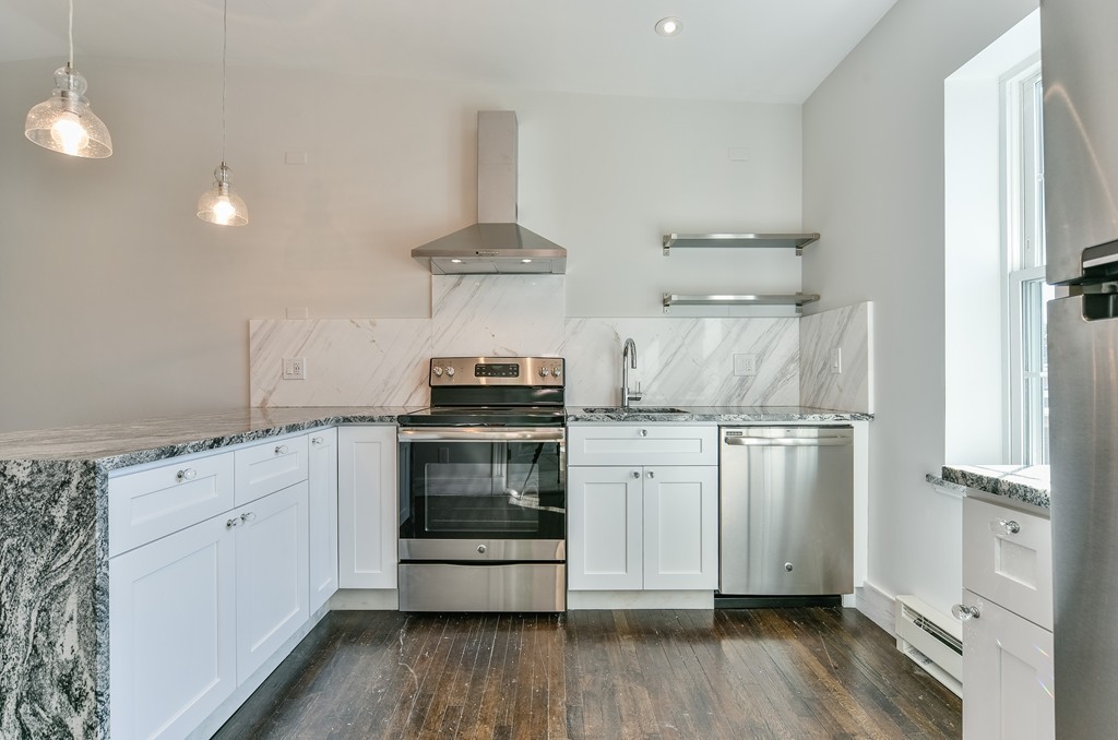 a kitchen with stainless steel appliances a stove refrigerator and cabinets