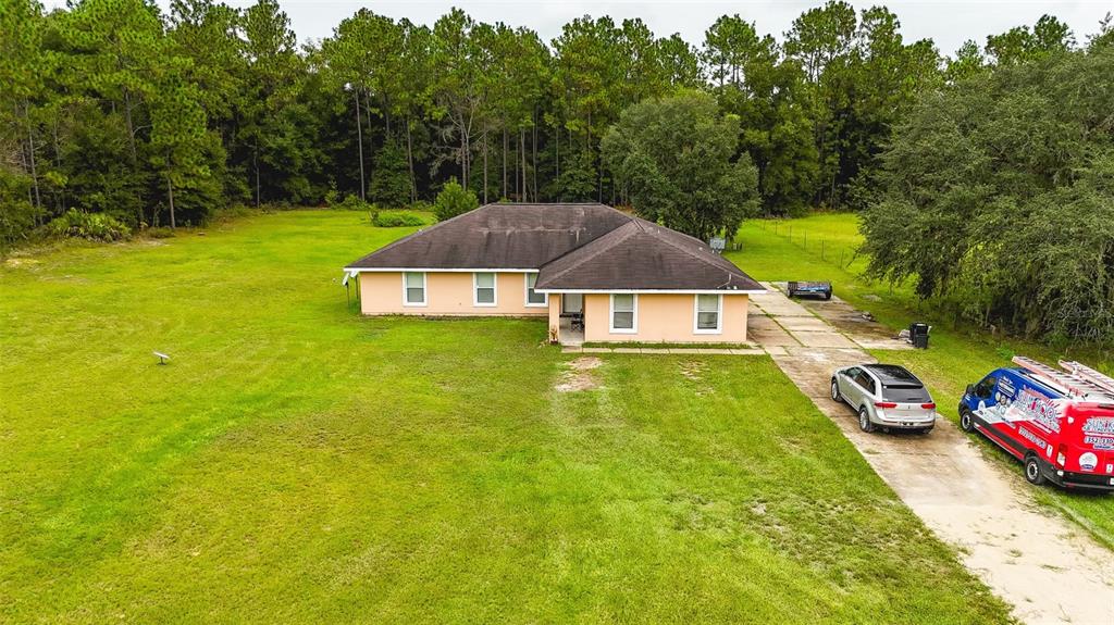 a aerial view of a house with swimming pool and next to a yard