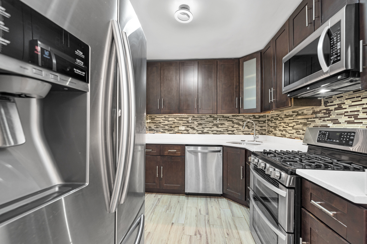 a kitchen with stainless steel appliances granite countertop a refrigerator a stove a sink and dishwasher