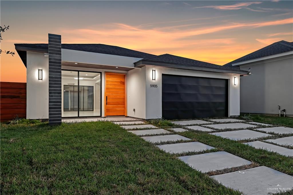 View of front of home featuring a lawn and a garage