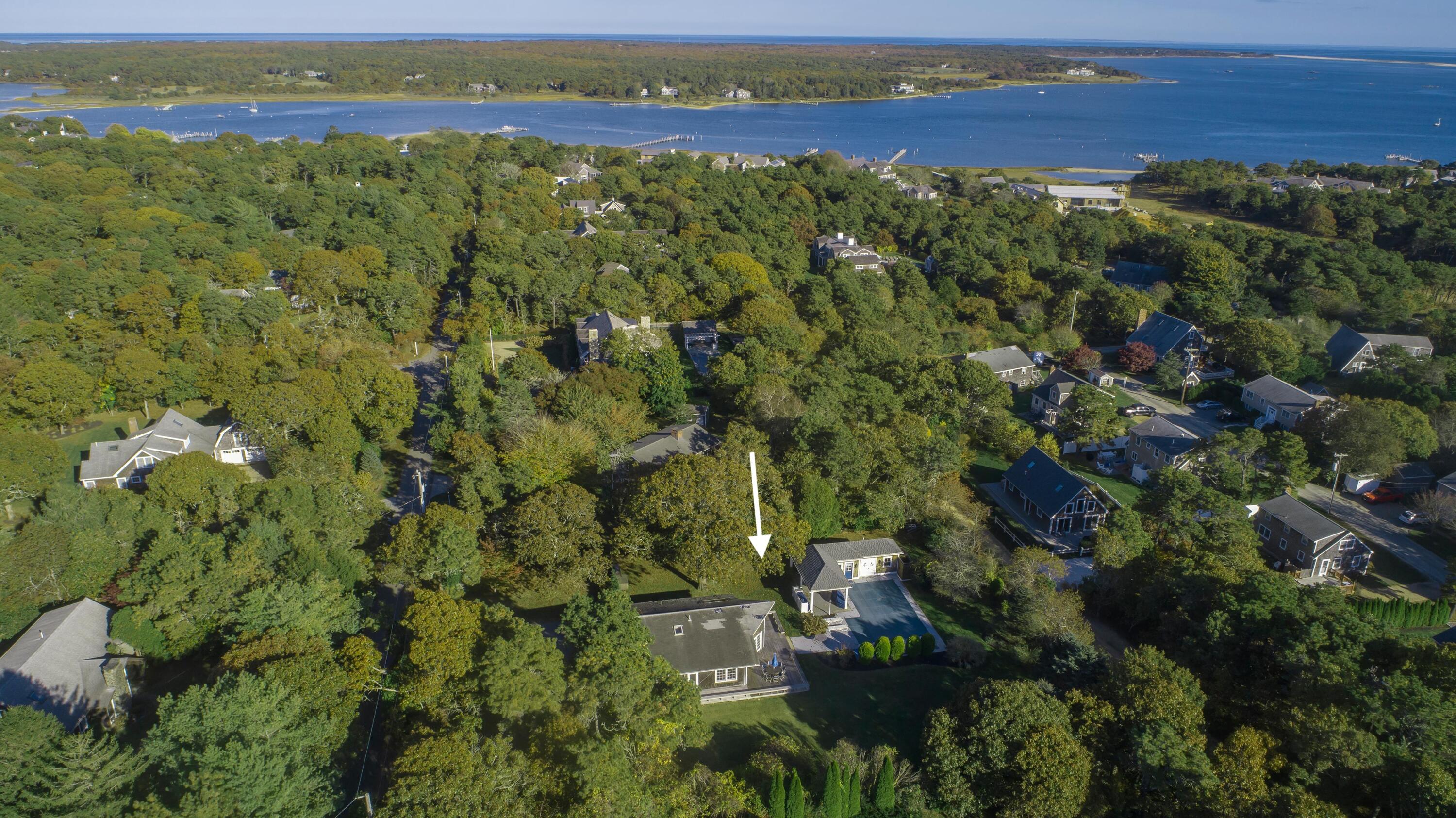 an aerial view of residential houses with outdoor space and trees