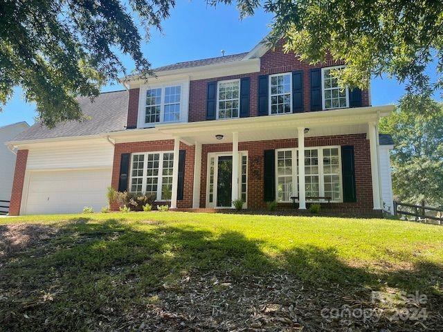 front view of a brick house with a yard