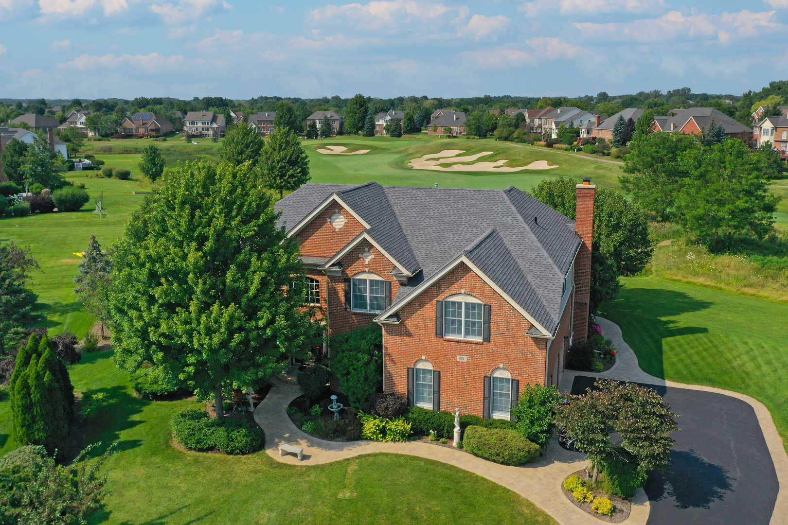 an aerial view of a house with a yard and lake view